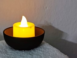 Photograph of LED candle lit in a bowl