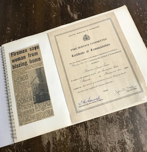 George's certificate of commendation awarded during his time as a firefighter and newspaper extract titled 'firemen save woman from blazing home'
