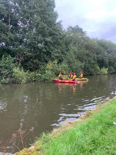 GMFRS crew on boats on the canal trying to reach an injured bird on the banks