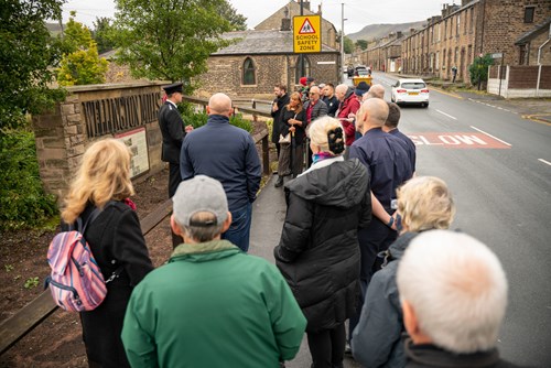 Mossley Station Manager Dave Swallow talking to onlookers stood on a road during the ceremony