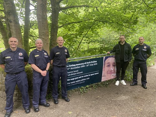 GMFRS colleagues with Chris Jordan next to water safety banner