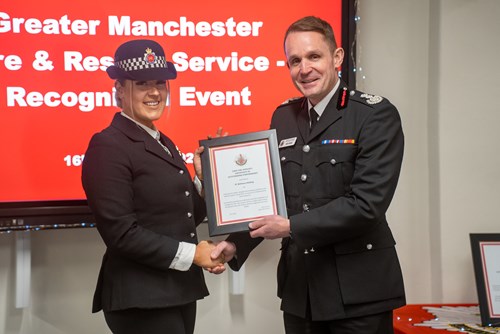 PC Beth Holding shakes hands with CFO Dave Russel while receiving her award at the Greater Manchester Fire & Rescue Service Recognition Event