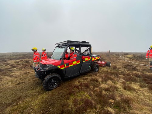 A GMFRS all-terrain vehicle drives across moorland