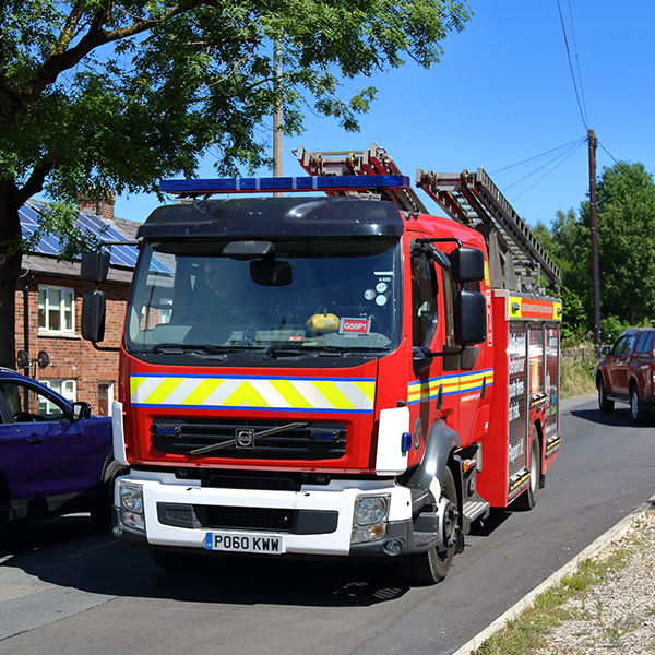 Fire engine in the road with bright-blue sky behind