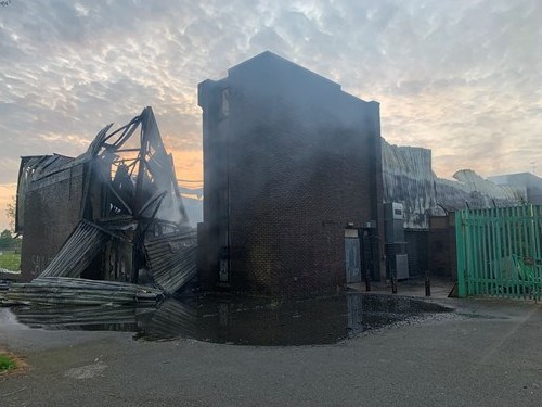 An exterior view of the rear of a fire-damaged brick building