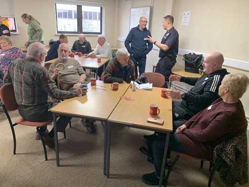 Living well group members sat around tables with refreshments chatting to each other